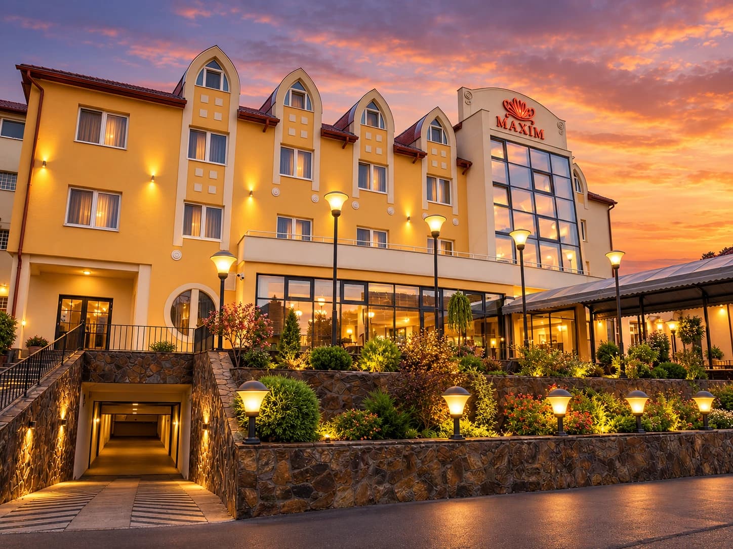 Hotel Maxim façade lit up at sunset